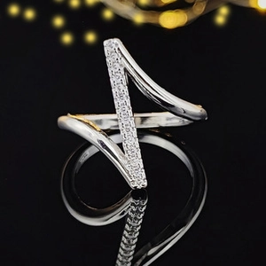Vue macro d'une bague géométrique en argent avec zircons sur un fond réfléchissant