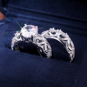 Primer plano de dos anillos vintage calados con cristal redondo en estuche de terciopelo