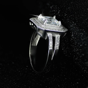 Macro side view of luxury emerald-cut diamond ring with halo setting on black background
