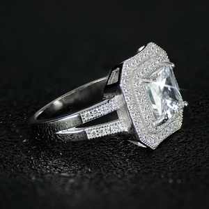Macro side view of luxury silver emerald-cut square ring with double halo setting