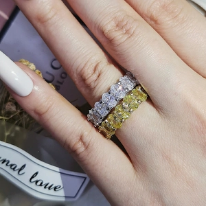 Detailed view of stacked silver and gold eternity rings with oval-cut cubic zirconia