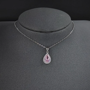 Gros plan détaillé d'un collier en cristal rose en forme de poire avec monture argent