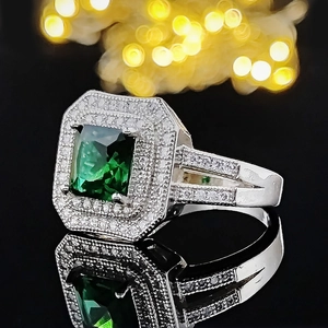 Luxury emerald-cut green gemstone ring with double halo diamonds on silver band