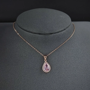 Détail du pendentif zircon rose poire avec halo en or rose et chaîne fine en O