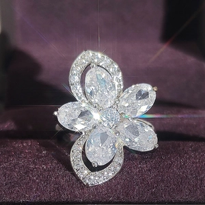Exquisite flower ring with marquise zircon petals and silver plating on purple velvet background