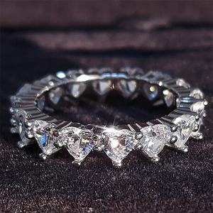 Macro shot of eternity ring with heart-cut cubic zirconia in three-prong silver setting