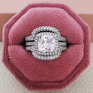 Detailed macro of cushion-cut luxury bridal ring set featuring a double halo and pavé band