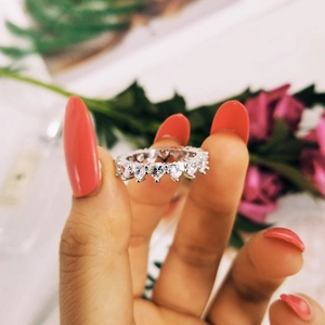 Close-up of sparkling heart-shaped zircon stones set in a silver eternity band