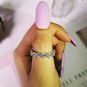 Macro shot of silver heart-shaped cubic zirconia ring on a manicured hand