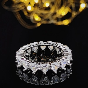 Elegant heart-cut eternity ring with sparkling stones on a reflective black background