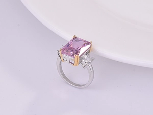 Macro shot of large pink rectangular crystal with gold prongs and silver band