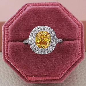 Lujoso anillo de circón amarillo con doble halo pavé en una caja de terciopelo