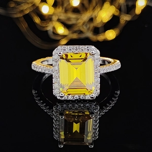 Luxurious champagne square-cut gemstone ring with pave diamonds on a reflective base