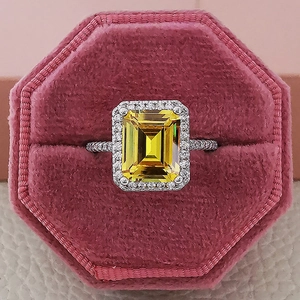 Champagne yellow emerald-cut gemstone ring with halo diamonds in a pink velvet jewelry box