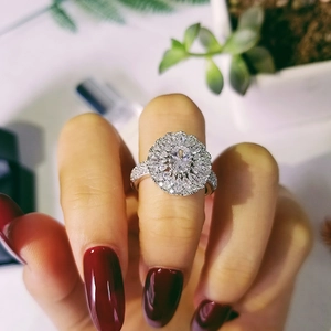 Macro view of vintage silver floral ring featuring oval center stone and full diamond paving