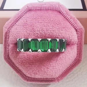 Makroaufnahme eines Eternity-Rings mit grünen Zirkonia im Smaragdschliff