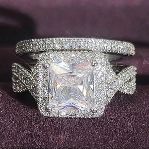 Nahaufnahme von Luxus Verlobungsring Set mit eckigem Hauptstein und Diamantbesatz