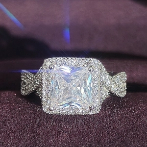 Nahaufnahme eines Halo-Rings im Prinzess-Schliff mit Pavé-Band auf lila Samthintergrund
