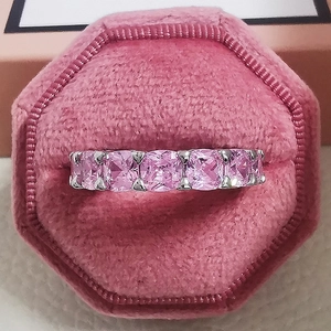 Makroaufnahme Silberring mit rosa Zirkon-Steinen in einer rosa Samtschmuckschatulle