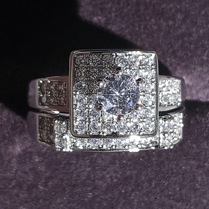 Macro shot of a double square-halo wedding ring set with cubic zirconia on purple velvet