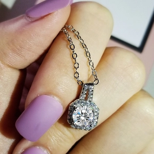 Handheld view of a hexagon pavé halo necklace with brilliant round zircon in 925 silver