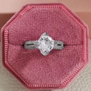 Top view of a round brilliant cut halo engagement ring in a pink velvet jewelry box