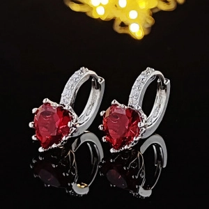 Primer plano de pendientes de rubí en forma de corazón con pavé de circonitas en plata