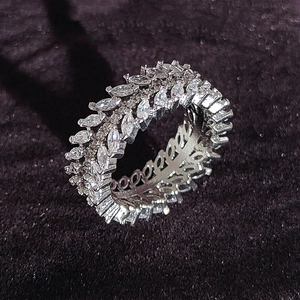 Macro detail of wide luxury ring featuring marquise-cut crystals on dark velvet