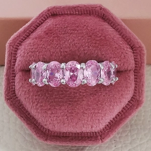 Detail von fünf rosa Edelsteinen im Ovalschliff auf einem luxuriösen Ewigkeitsring