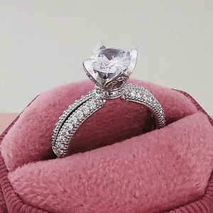 Elegant vintage engagement ring with large round solitaire and pave diamonds in a pink box