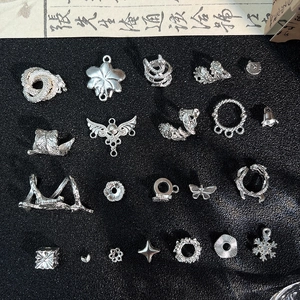 Dettaglio di varie perline e ciondoli in lega d'argento per creazione gioielli fai da te