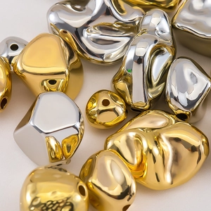 Macro shot of irregular metallic beads in gold and silver for DIY jewelry making