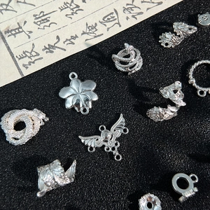 Dettaglio di ciondoli in lega d'argento vintage con motivi di drago, serpente e fiori