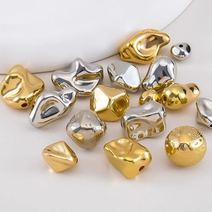 Close-up of irregular molten gold and silver beads with mirror finish and pre-drilled holes