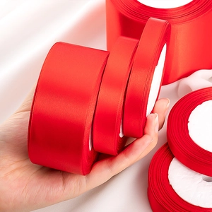 Polished red satin ribbon rolls in various widths for gift wrapping and wedding decor