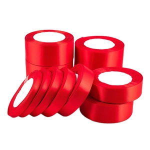 Rolls of bright red polyester satin ribbons in various widths for gift wrapping and wedding decor