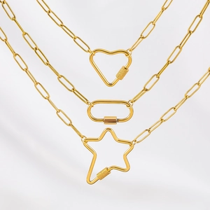 Detail van gouden paperclipkettingen met hart-, ster- en ovale karabijnhaak-hangers
