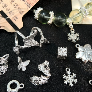 Dettaglio macro di ciondoli vintage in argento e perline per la creazione di gioielli