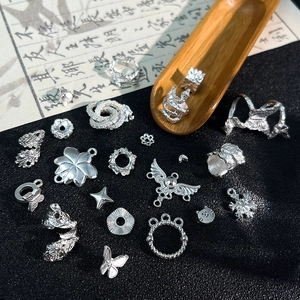 Dettaglio di vari ciondoli in argento vintage inclusi farfalle e fiori per gioielli fai-da-te