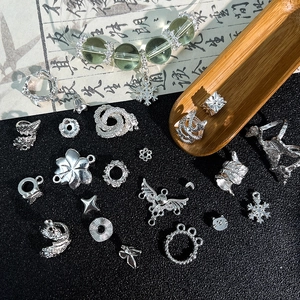 Dettaglio di ciondoli in argento e perline verdi su sfondo decorativo in stile retrò