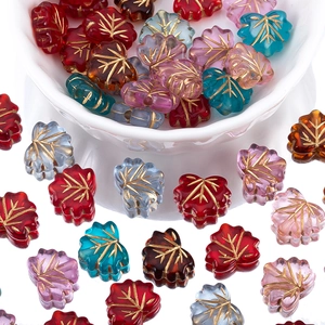 Macro detail of acrylic maple leaf beads with golden veins for DIY jewelry making