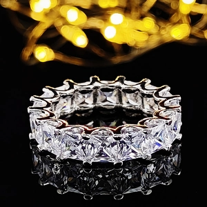 Anillo de eternidad en plata con cristales de corte esmeralda y reflejo sobre fondo negro