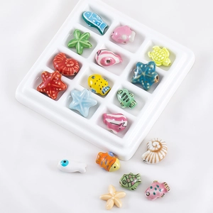 Macro shot of ocean series beads with starfish and fish designs in a sorting tray