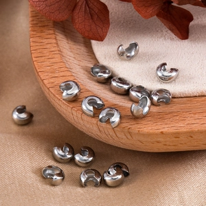 Macro shot of silver 4mm C-shaped crimp bead covers for DIY jewelry making and crafts