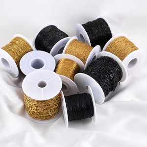 Detail view of gold and black stainless steel jewelry chains on reels for DIY making