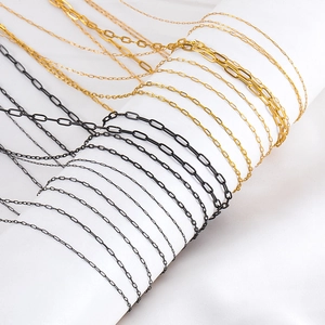Macro view of stainless steel paperclip and fine link chains on jewelry display