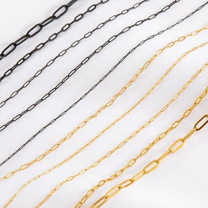 Detail of multi-size stainless steel paperclip chains in black and gold vacuum plating