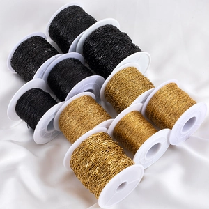 Detailed close-up of gold and black stainless steel DIY jewelry chains on white spools
