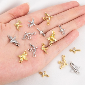 Detail of Cupid arrows and cross charms in gold and silver plating for DIY jewelry