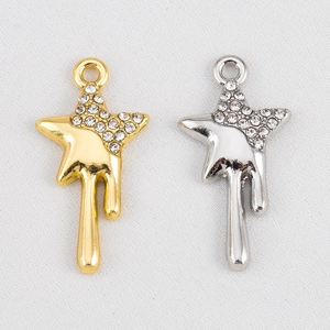 Détail macro de pendentifs étoiles fluides en or et argent avec strass étincelants